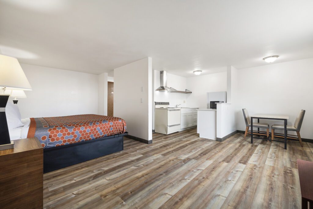 Hotel room at Kennewick Inn & Suites Tri Cities with one king bed, dining table, diningchairs, and in-room kitchen.