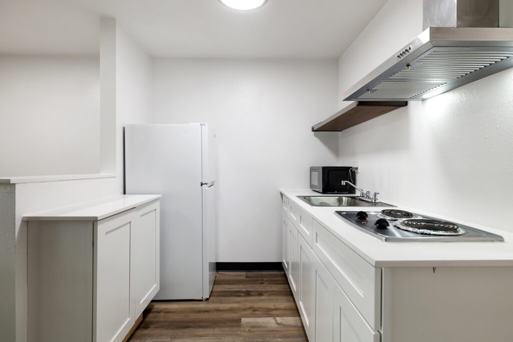 In-room kitchen with stove, refrigerator, sink and microwave at Kennewick Inn & Suites Tri Cities.