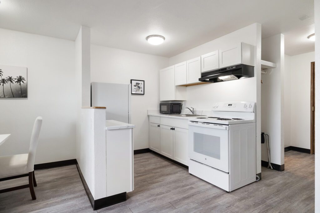 Dining room and in-room kitchen with stove, refrigerator, sink and microwave at Kennewick Inn & Suites Tri Cities.