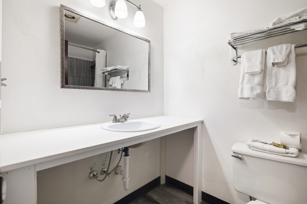 Hotel bathroom with sink, mirror, and toilet at Kennewick Inn & Suites Tri Cities.