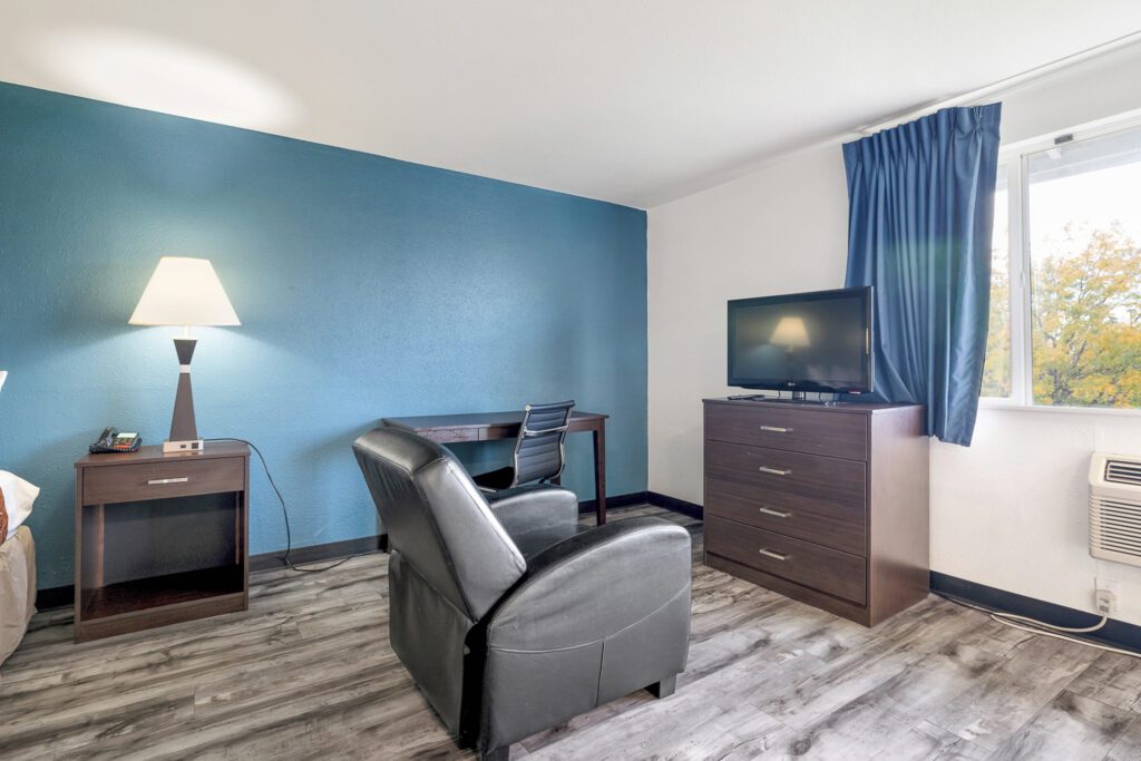 Living area with recliner, TV, and desk at Kennewick Inn & Suites Tri Cities