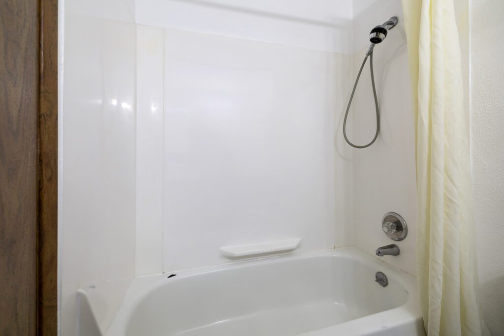 Hotel room bathroom at Kennewick Inn & Suites Tri Cities with a shower and bathtub.