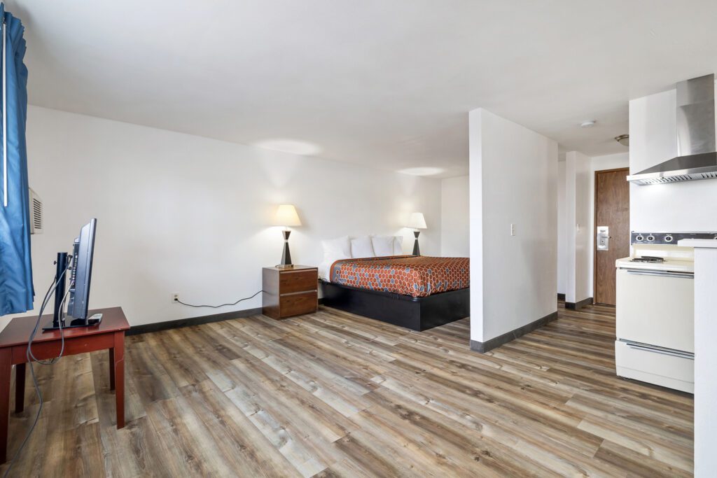 Hotel room at Kennewick Inn & Suites Tri Cities with one king bed, TV, and in-room kitchen.