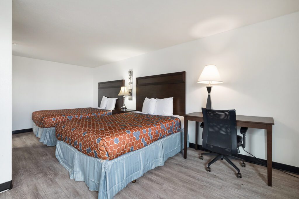 Hotel room with two queen beds, work desk, and chair at Kennewick Inn & Suites Tri Cities.