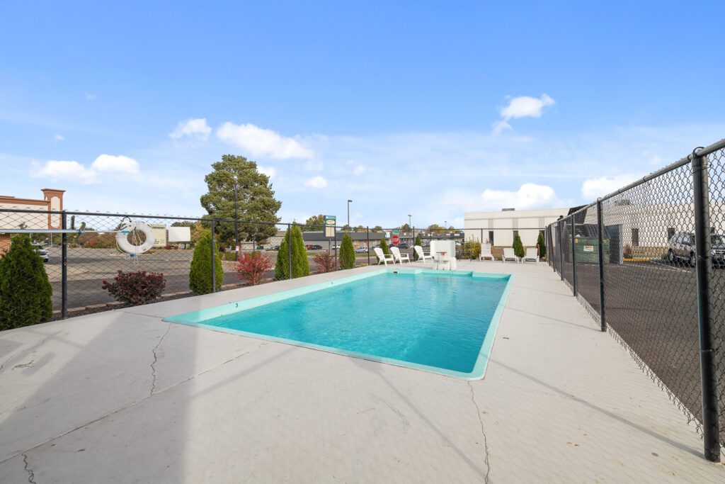 Outdoor pool at Kennewick Inn & Suites Tri Cities with seating.