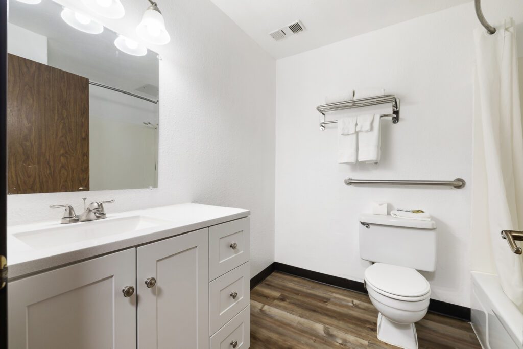 Hotel bathroom at Kennewick Inn & Suites Tri Cities with sink, mirror, and toilet.