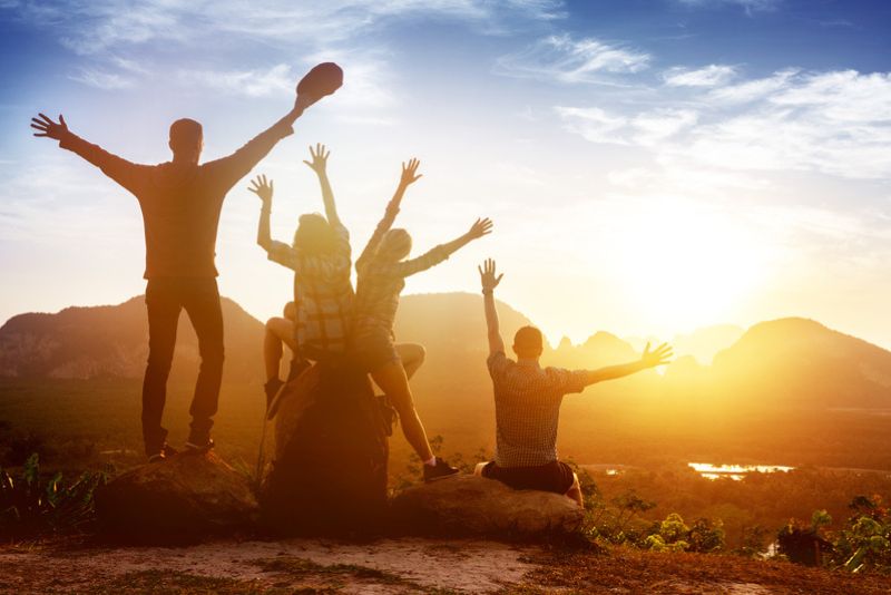 group travelers watching the sunset on a mountain